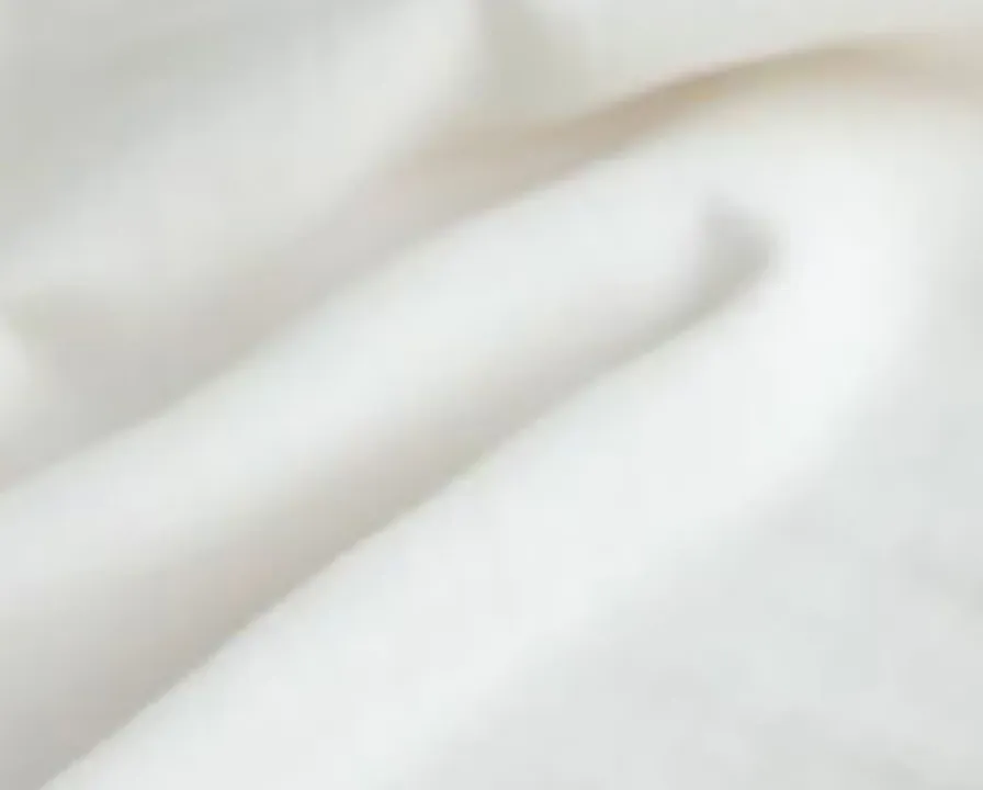 부드럽게 주름진 흰 침구